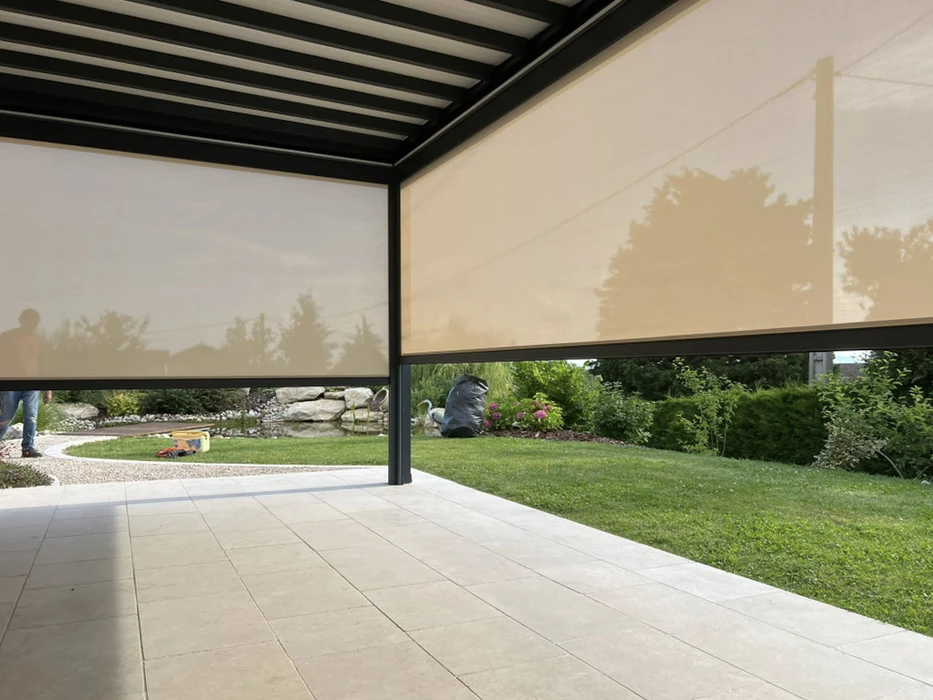 Terrasse couverte moderne avec pergola bioclimatique à lames orientables et stores extérieurs beiges déroulés