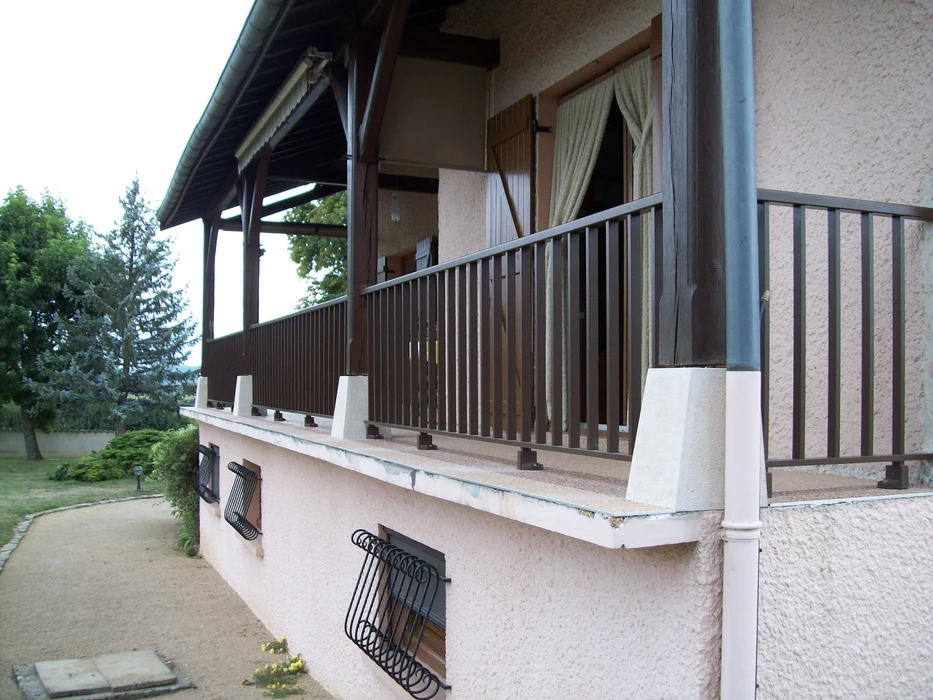 Balcon extérieur d'une maison résidentielle avec garde-corps en bois et métal
