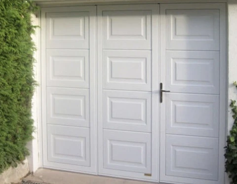 Extérieur résidentiel avec porte de garage sectionnelle blanche à trois vantaux