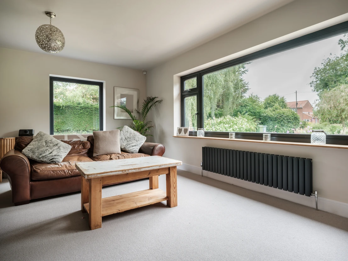 Intérieur résidentiel moderne avec porte en bois naturel équipée d'une poignée design métallique chromée