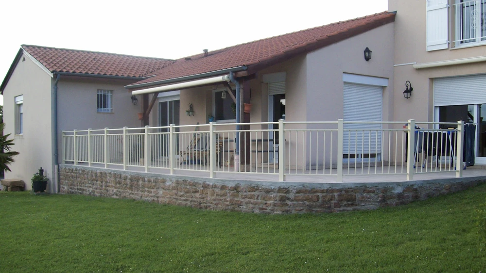 Portail métallique noir automatique ouvert sur route asphaltée, vignoble en arrière-plan