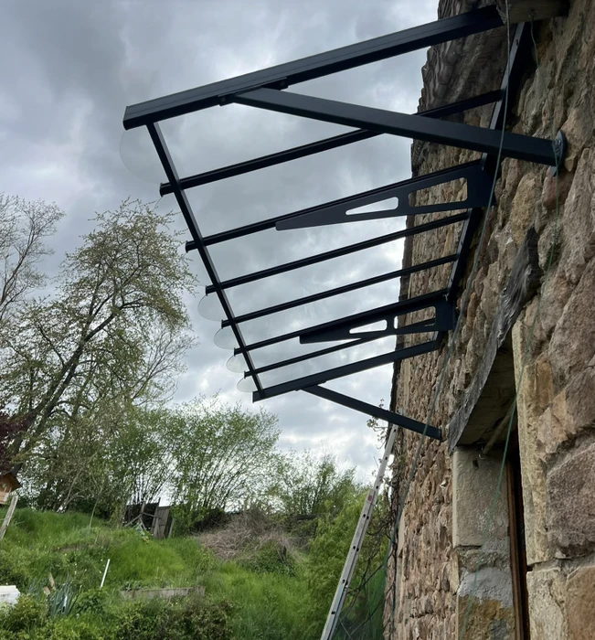 Terrasse extérieure couverte d'une pergola moderne avec store enrouleur blanc partiellement déployé