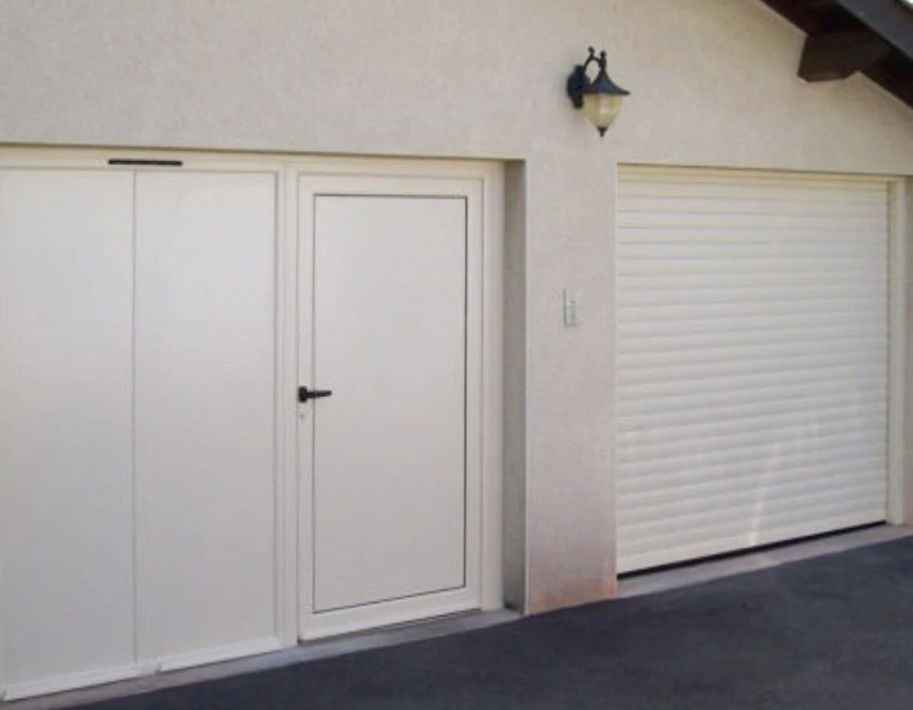 Façade extérieure d'une maison traditionnelle en pierre calcaire avec volets battants bordeaux, porte d'entrée vitrée assortie et véranda attenante