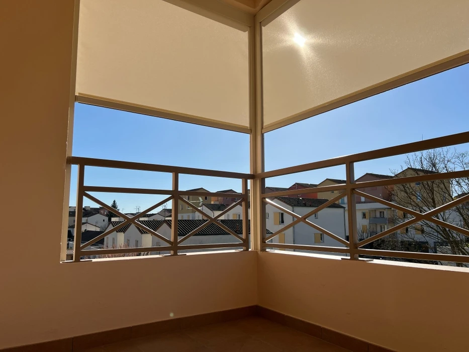 Terrasse couverte moderne avec pergola bioclimatique à lames orientables et stores extérieurs beiges déroulés