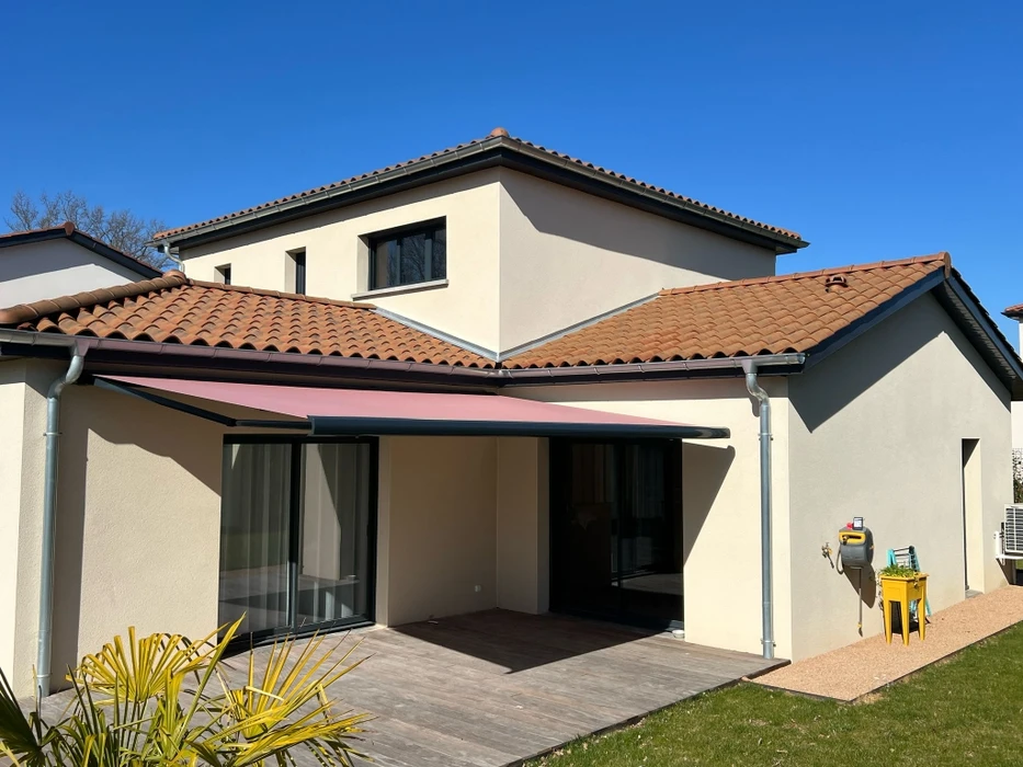 Terrasse couverte moderne avec pergola bioclimatique à lames orientables et stores extérieurs beiges déroulés