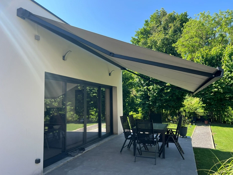 Terrasse couverte moderne avec pergola bioclimatique à lames orientables et stores extérieurs beiges déroulés