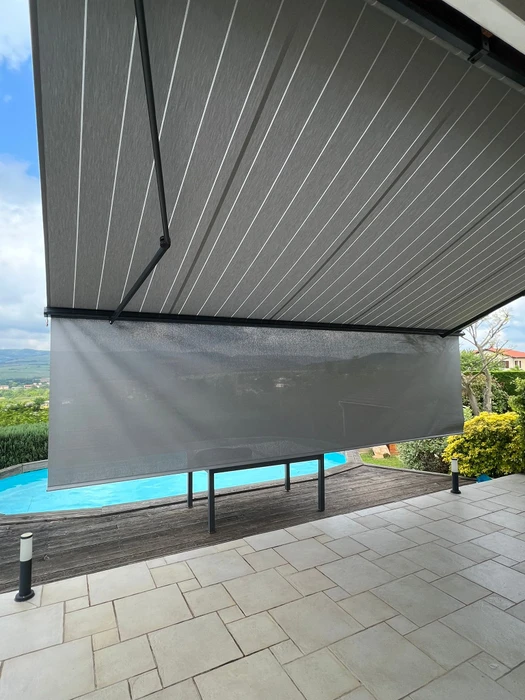 Terrasse couverte moderne avec pergola bioclimatique à lames orientables et stores extérieurs beiges déroulés