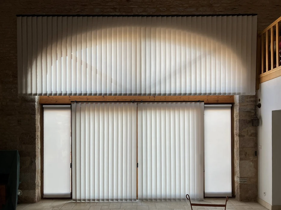 Terrasse extérieure d'une maison en pierre avec store banne orange déployé