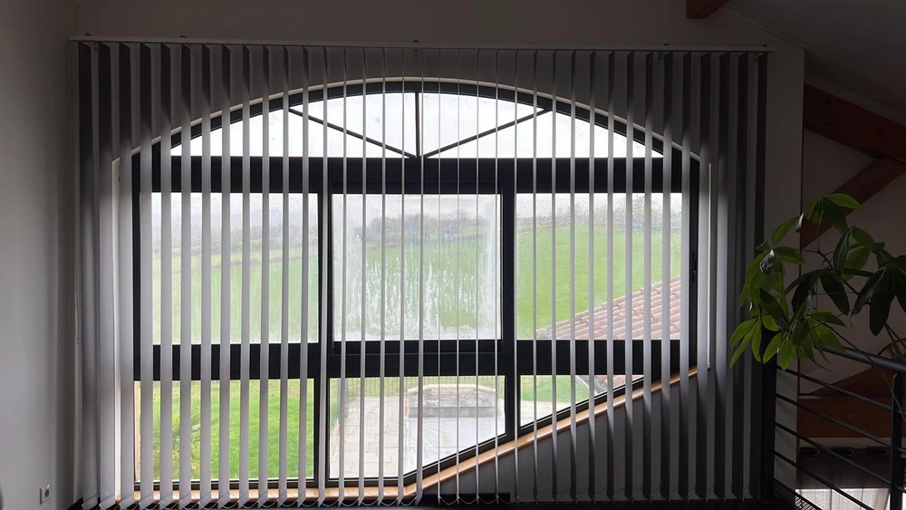 Terrasse couverte moderne avec pergola bioclimatique à lames orientables et stores extérieurs beiges déroulés