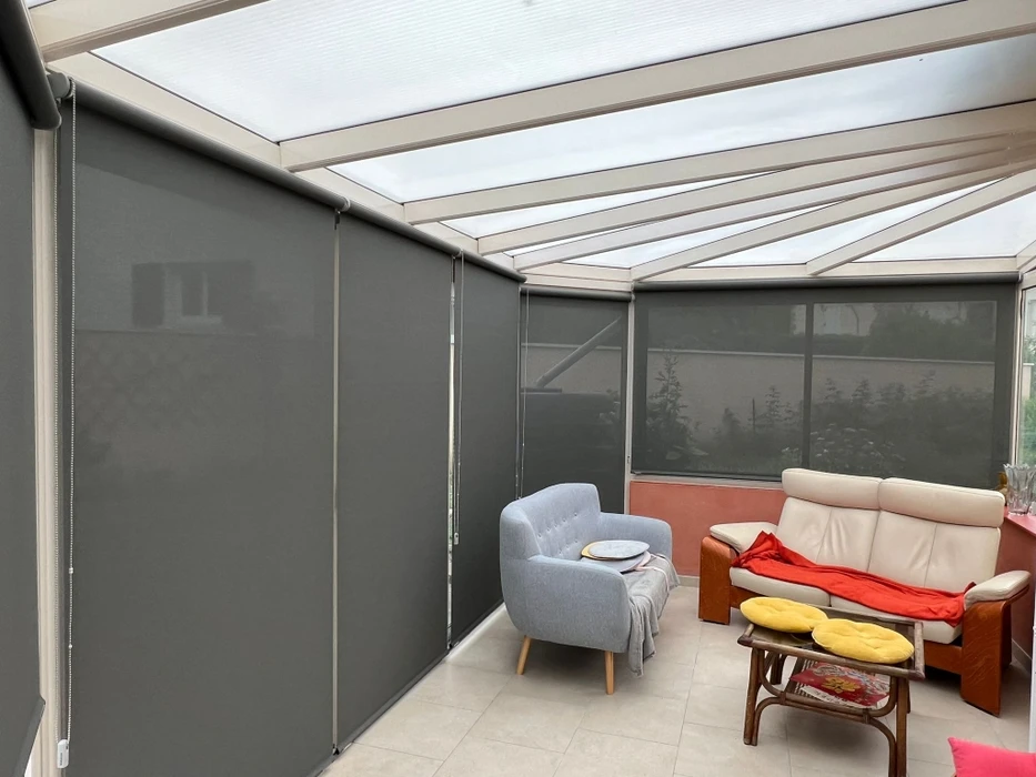 Terrasse extérieure moderne avec store banne déployé gris anthracite fixé sur façade contemporaine